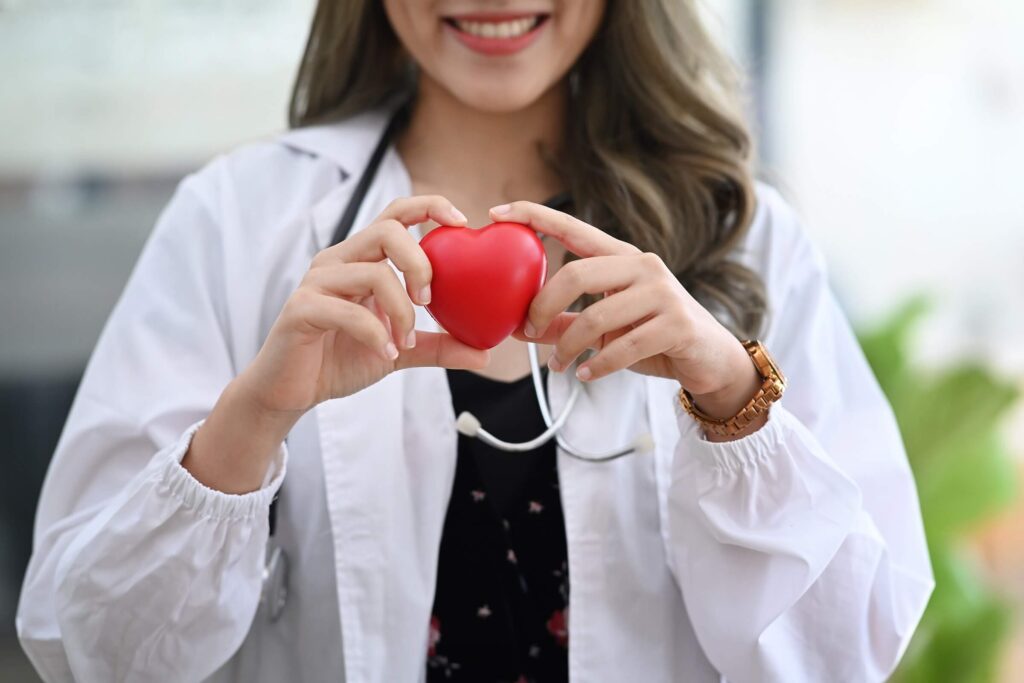 smiling female doctor with stethoscope holding red 2022 03 18 09 11 30 utc